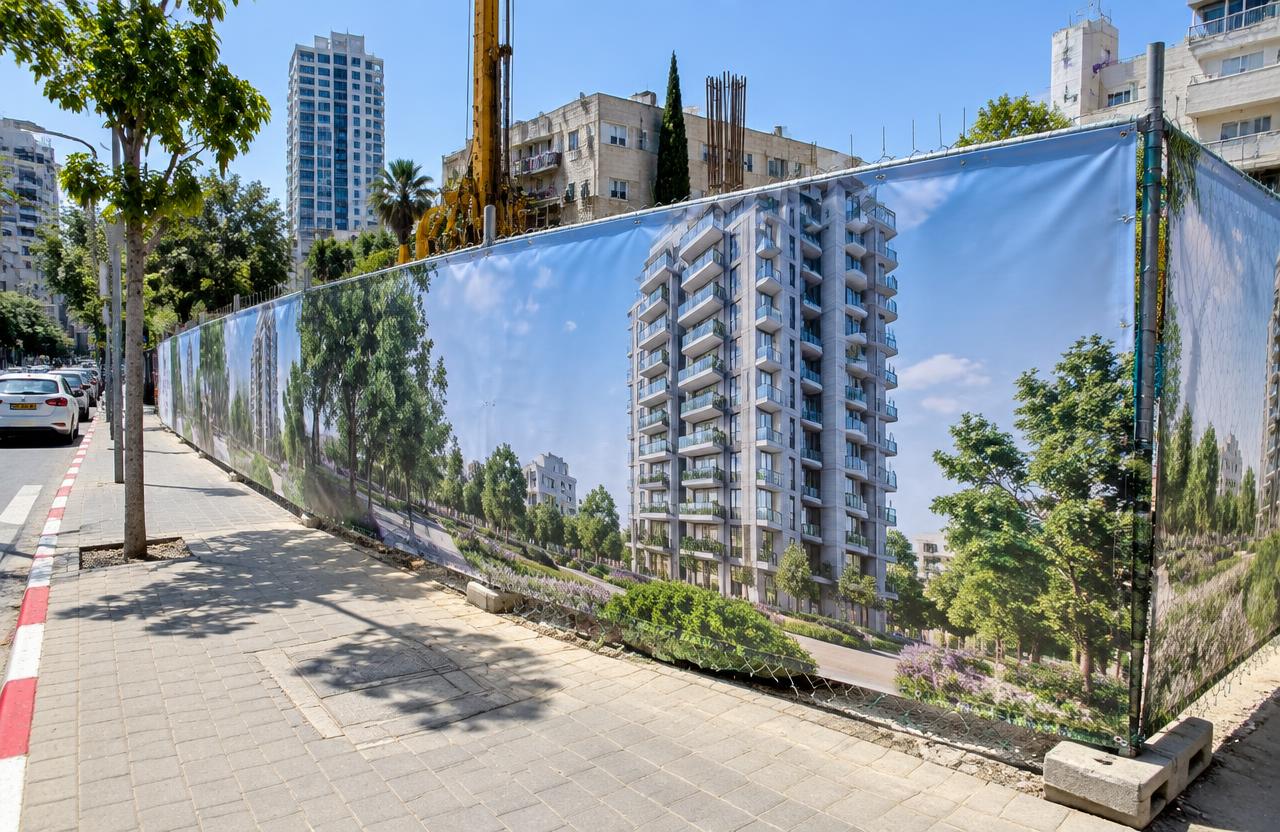 גדר אתר בנייה עטופה ביריעה מודפסת עם הדמיה של מגדל מגורים